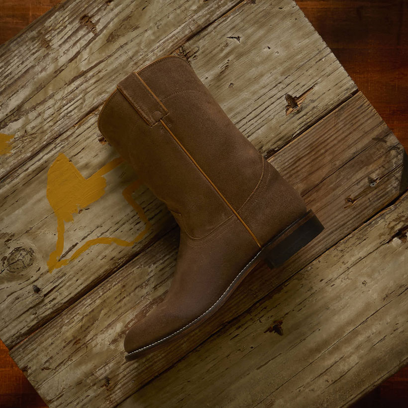 The Wes 10" Suede Roper boots in Butterscotch (Tan) on a table made of wood