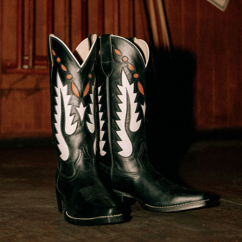 The Faye 13" Western in black in front of a cabinet.