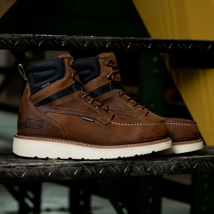 The Garren 6" Waterproof Steel Toe work boot in brown sitting on a steps.