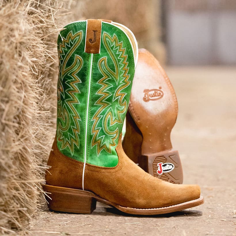 The Jimmy 13" Western boots in Sedona Tan next to a bale of hay.