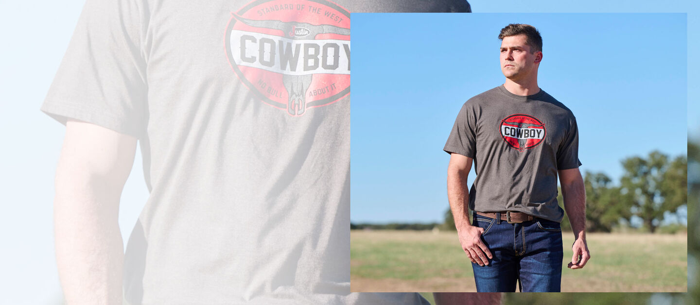 A Man standing in a field wearing a Justin Cowboy graphic t-shirt.
