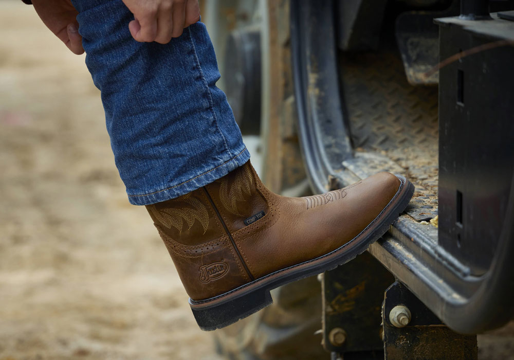 A man wearing the Handler 11" Comp Toe in Brown.