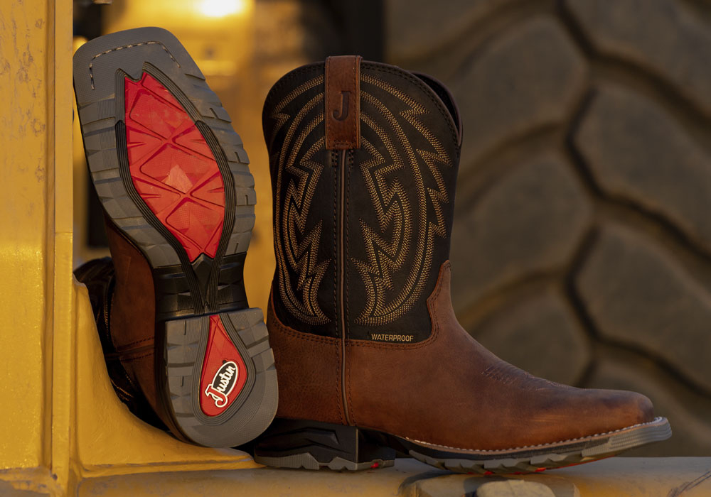 The Lytle 11" Waterproof Steel Toe Work boot in Brown / Black in front of a tractor.