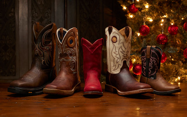 Men’s Pascoe western boot in antique saddle, Women’s Cowgal western boot in black, and Kids Rush junior western boot under a Christmas tree.