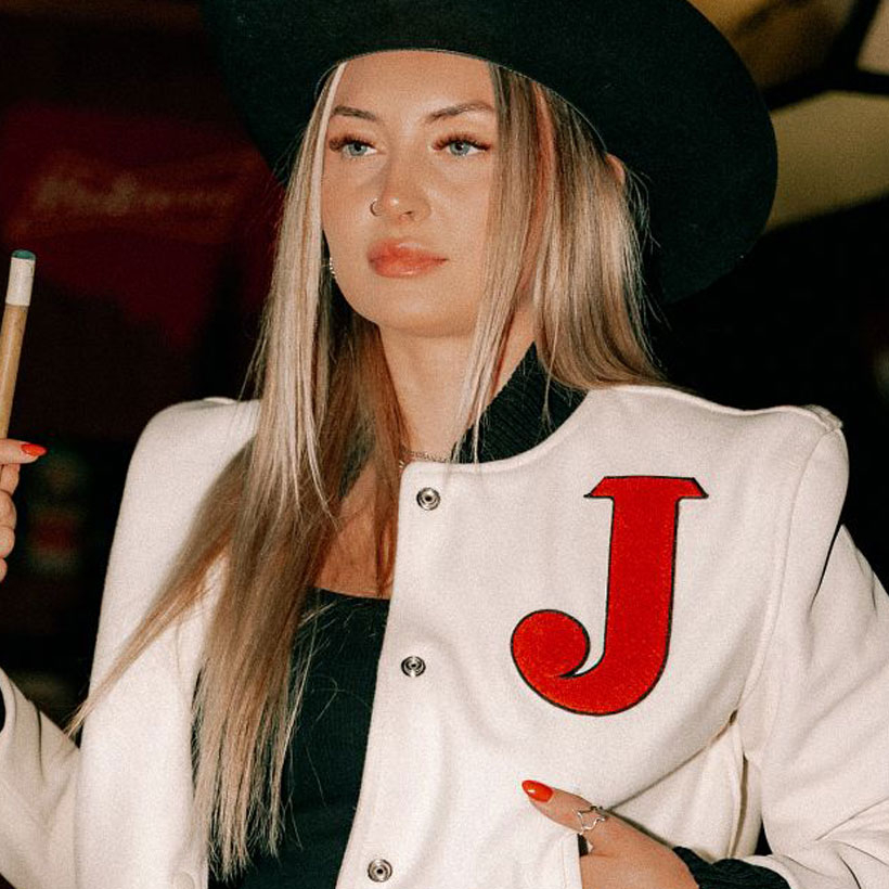 A woman wearing the Justin Women's Varsity Jacket in white an black.