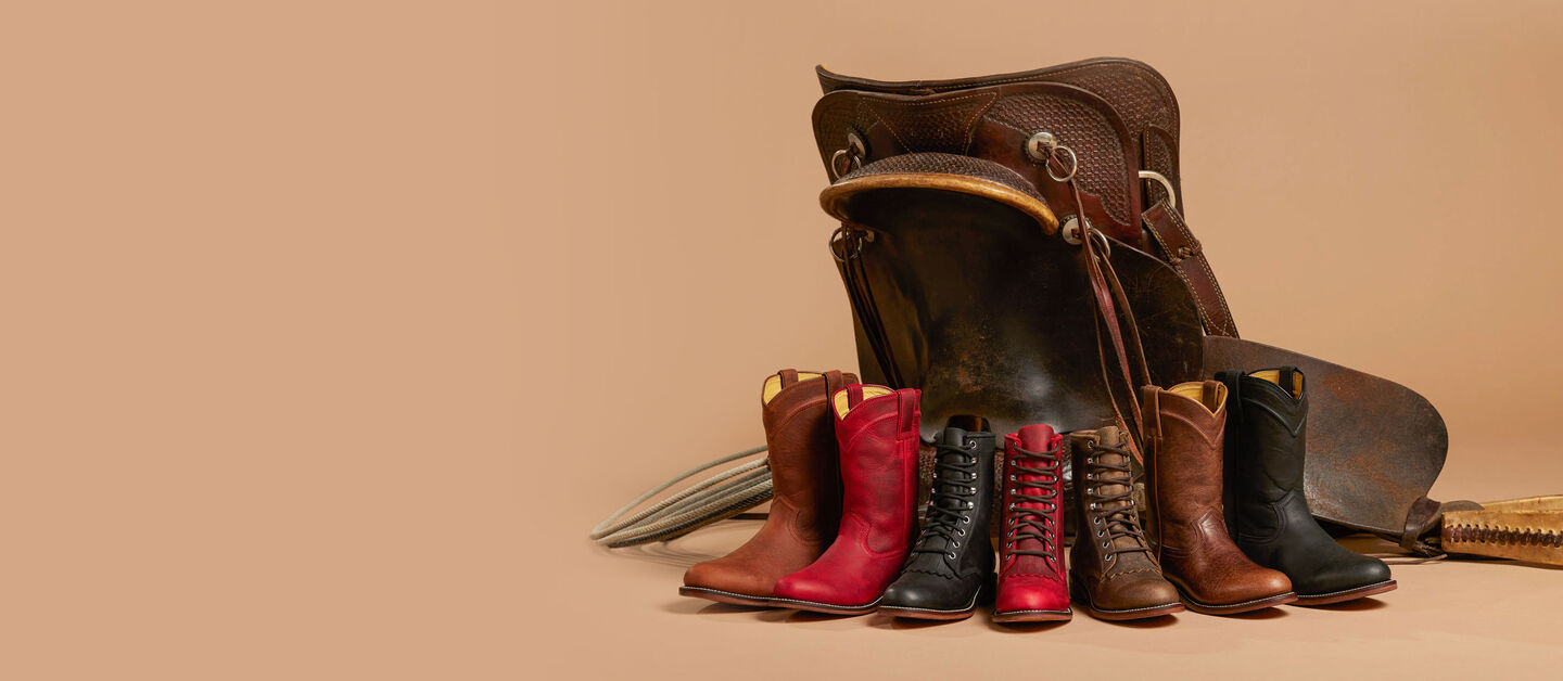 A group of Men’s and Women’s Justin Ropers in front of a saddle.