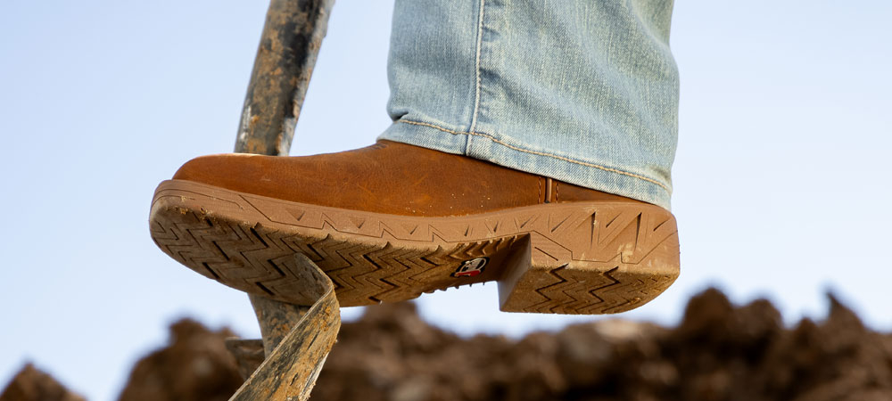 A man wearing the Blinder 11" Waterproof Steel Toe Brown while digging with a shovel.