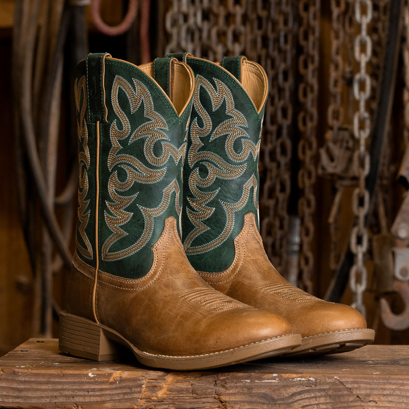 The Jasper 11" Western Boots in chestnut tan on a work bench.