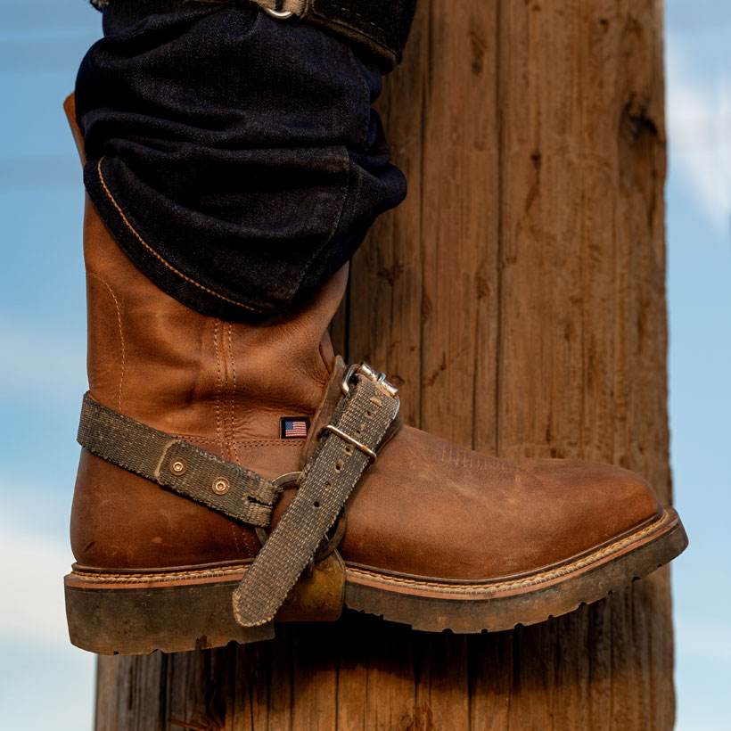 A man wearing the Ames 11" Steel Toe Waterproof boots in Walnut Brown.