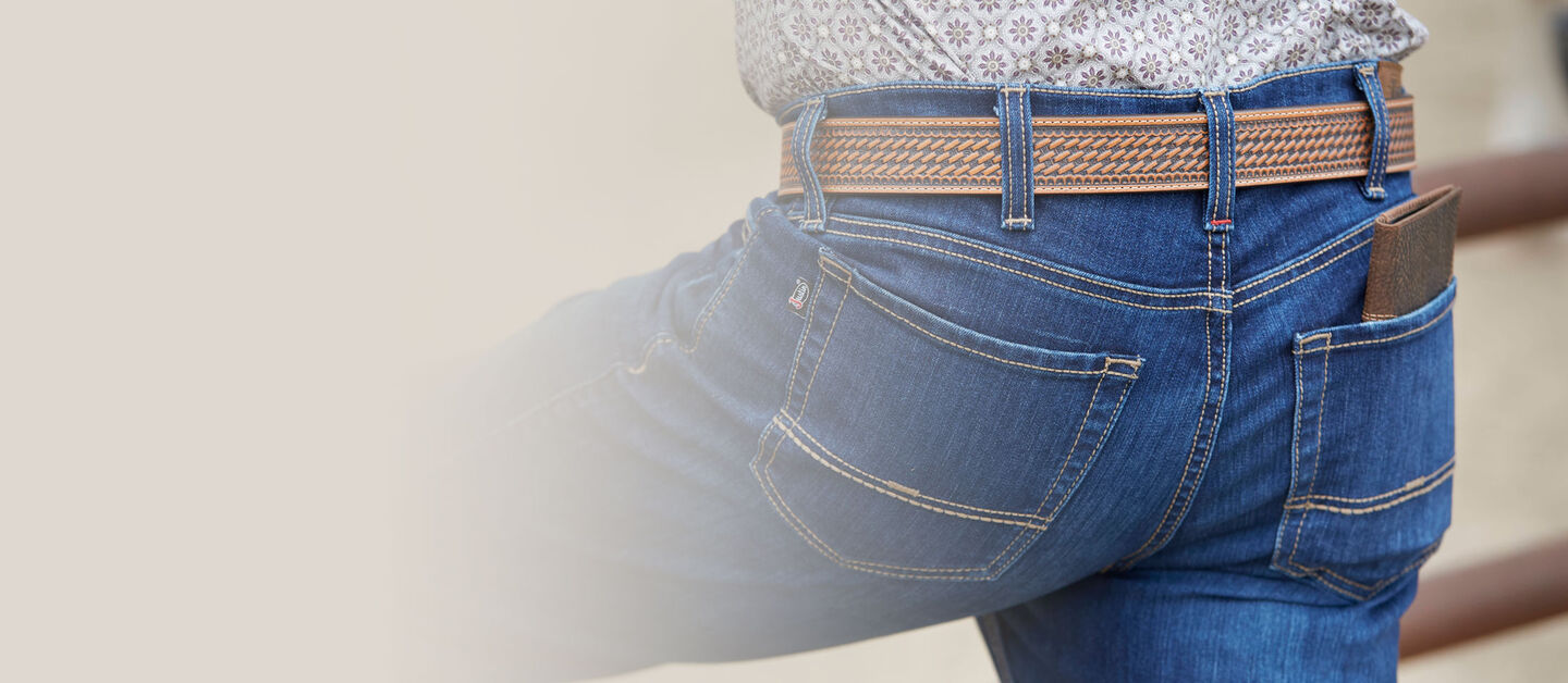 A close-up of a man wearing Justin Jeans and a Justin Belt.