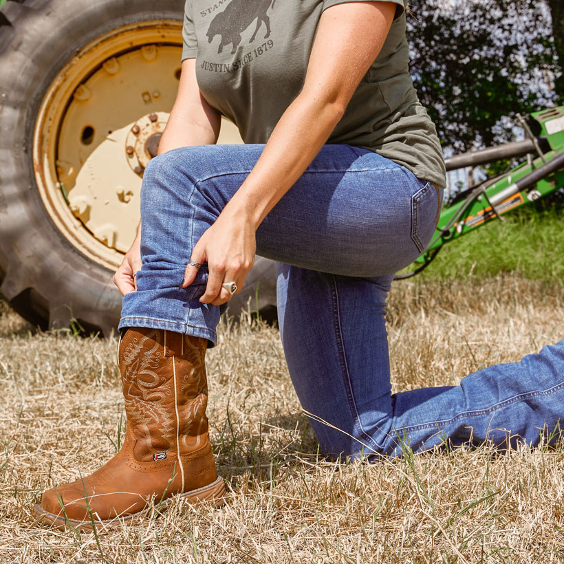 A woman wearing the Rush 11" Waterproof Work Boot in Rustic Tan.