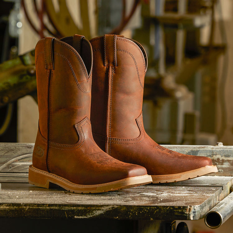 Men’s Buster II 11" Waterproof Steel Toe in brown sitting on a workbench in a shop. 