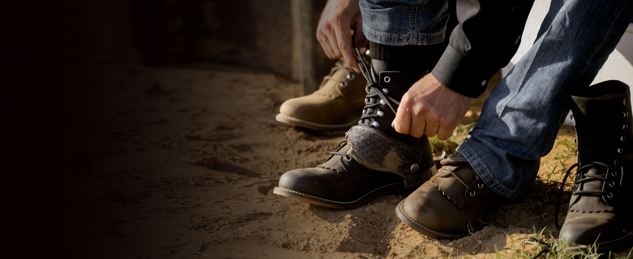 A man tying the lace of his Justin Ropers