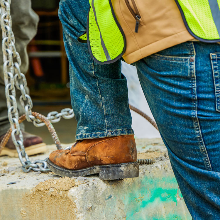 Men’s Conductor 8” work boots in brown worn by a construction worker man working on a job site.