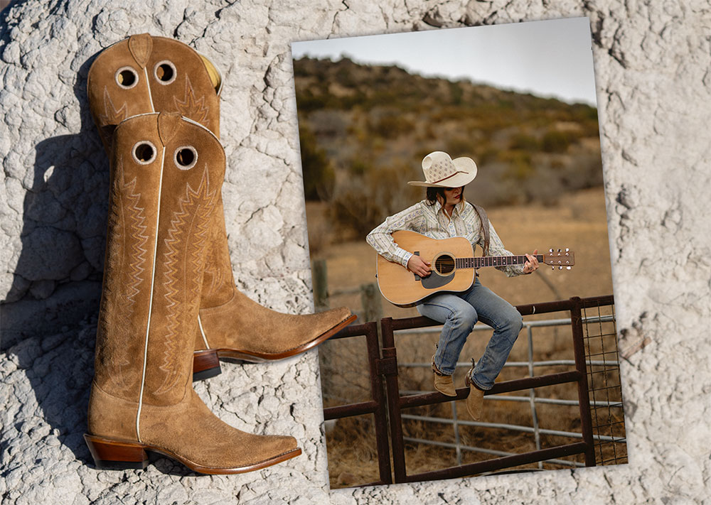 Jenna Paulette wearing the Sunrise boots in tan suede and sitting on a fence, holding her guitar. 