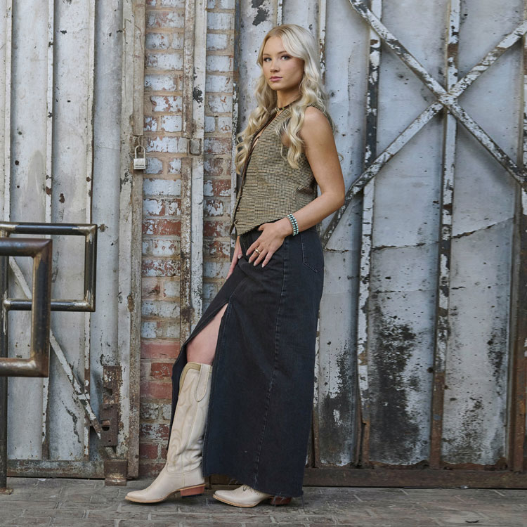 Women’s Verlie 17” Women’s Western Boot in white worn by a woman in a denim skirt. 