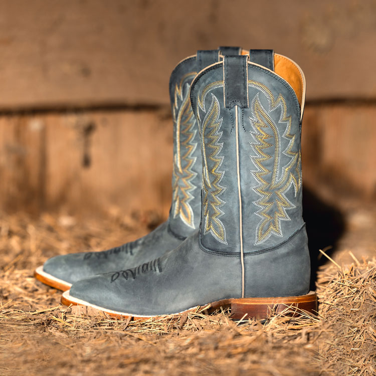 Men’s Rancho 11” Western boots in grey sitting in hay.