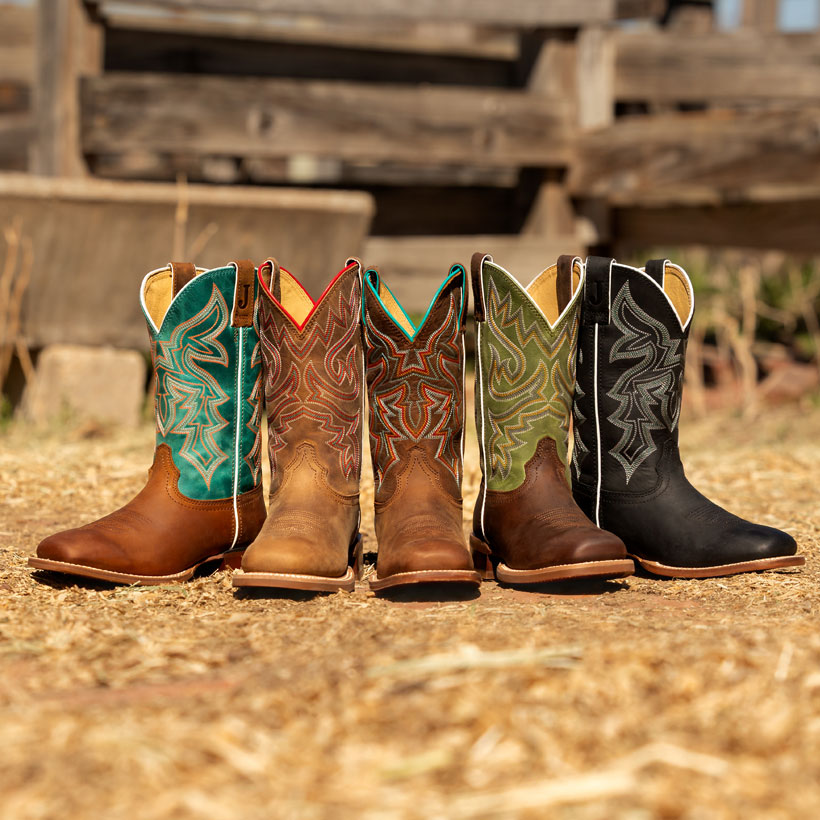 Women’s frontier collection of cowgirl boots in multiple colors posed in a horseshow near fencing.