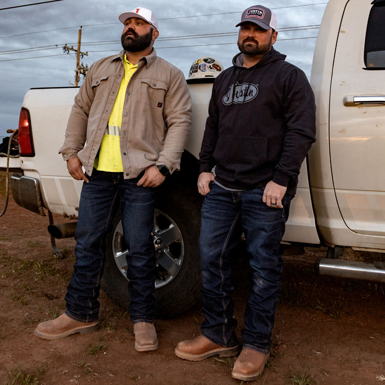 1879 Relaxed Bootcut Men's Jeans in medium wash blue worn by two men on a jobsite.