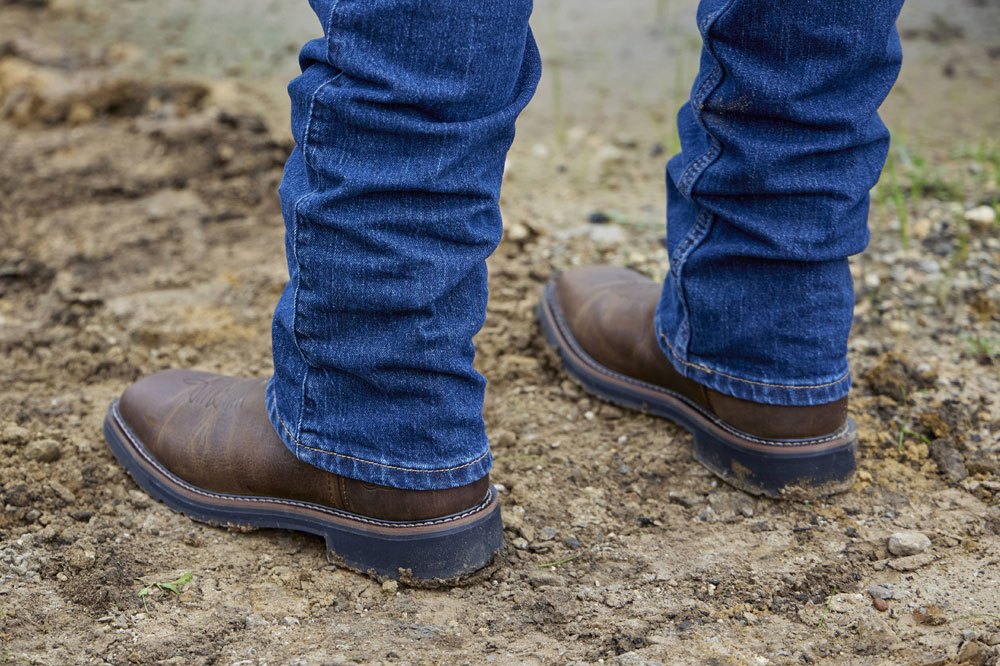 A man wearing Driller 11" Waterproof Steel Toe boot in brown.