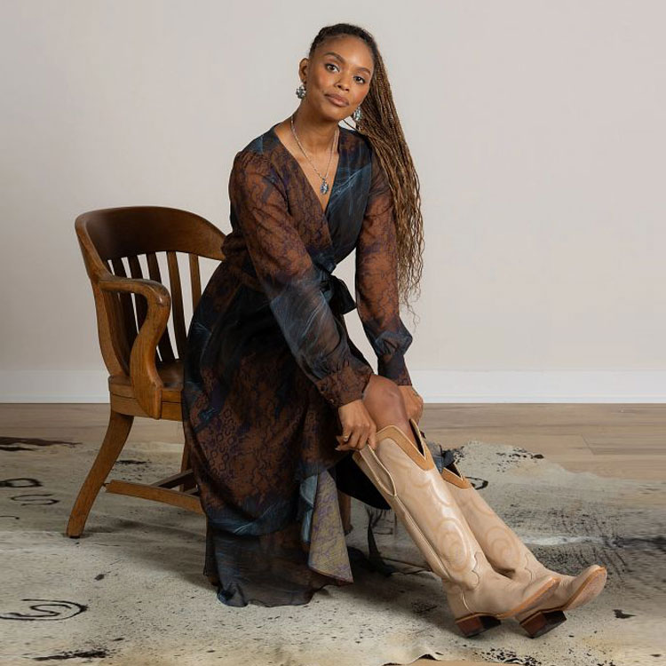 A woman sitting in a chair wearing a multicolored Justin wrap maxi dress 
