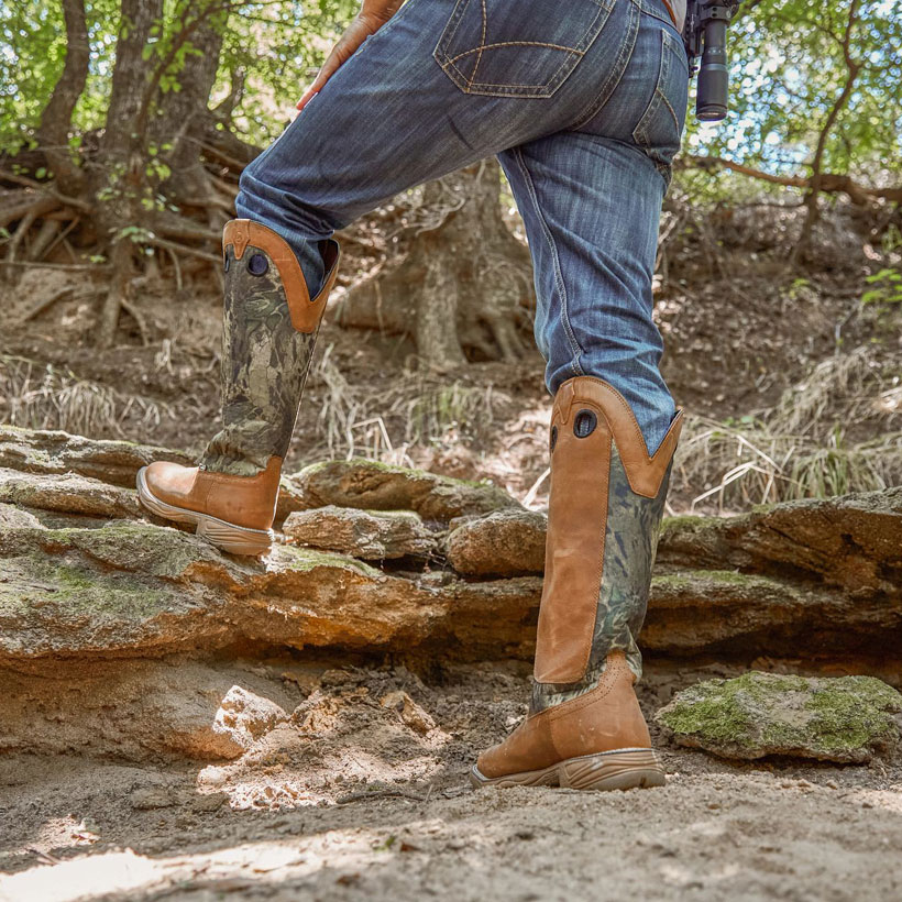 Men’s Rush Strike 17” Snake Resisting boots being worn by a man walking on rocks.
