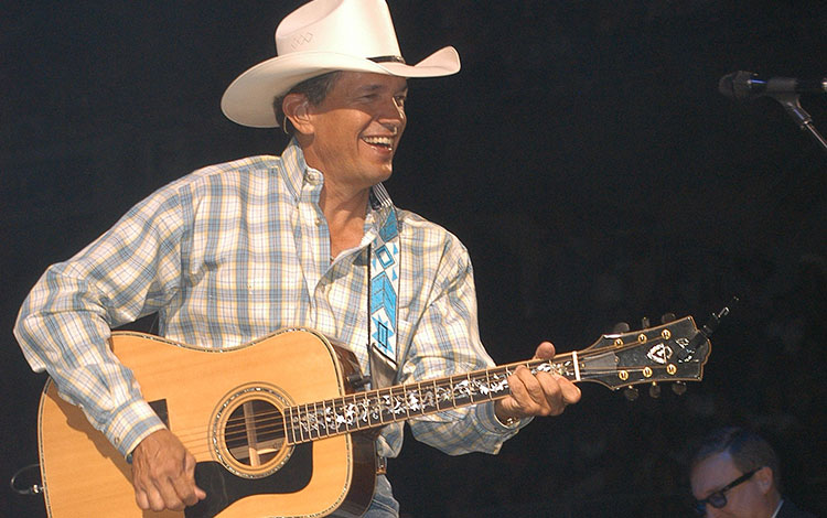 George Strait performing live with his guitar on stage