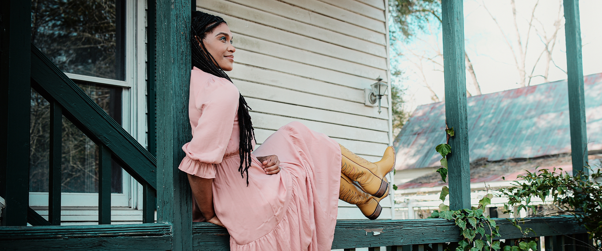 Cadance in pink dress and yellow boots sitting on banister outside house 